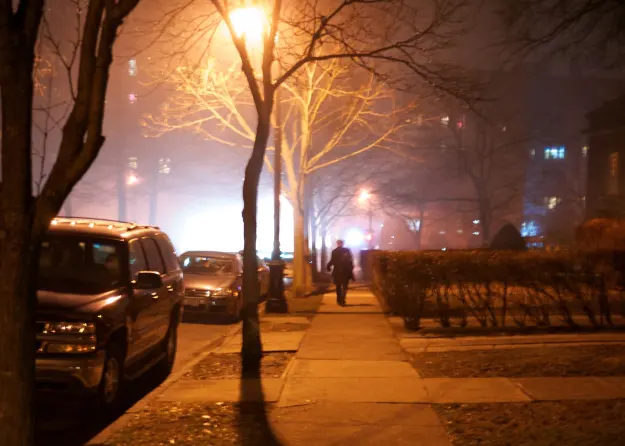 photo of man walking alone down sidewalk